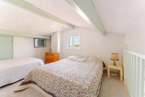 une chambre avec deux lits et une fenêtre dans l'établissement Appartement traversant vue sur l'étang, à Saintes-Maries-de-la-Mer