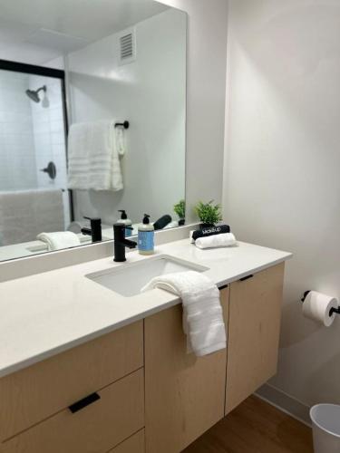 a bathroom with a sink and a mirror at Cityscape Peaks Penthouse DT Gym Free parking in Salt Lake City