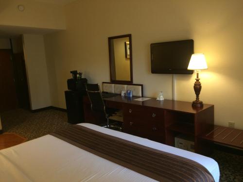 a hotel room with a bed and a desk with a computer at Baymont by Wyndham Columbia Fort Jackson in Columbia
