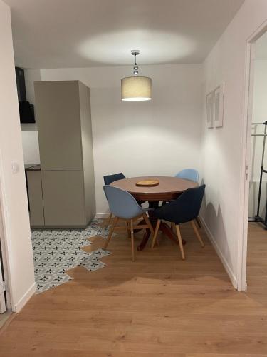 une salle à manger avec une table et des chaises bleues dans l'établissement T2 à deux pas de la plage, au Cap d'Agde