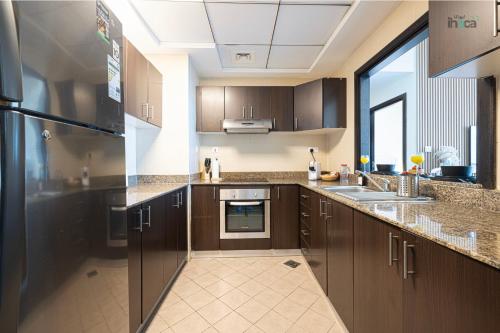 a kitchen with brown cabinets and a large window at 71st Floor Luxury 1Br Spacious Skyline Balcony in Dubai