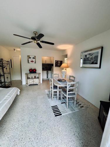 - un salon avec une table et un ventilateur de plafond dans l'établissement Beau T2, aperçu mer et accès plage, à Cavalaire-sur-Mer