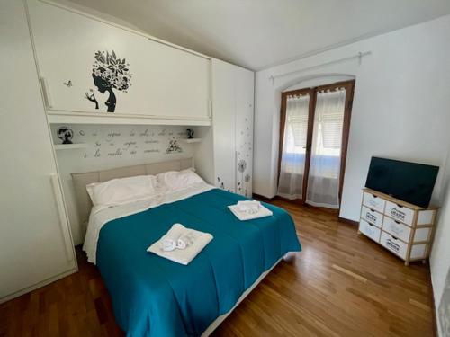 a bedroom with a blue bed with two towels on it at Tino'S House 2punto0 in La Spezia