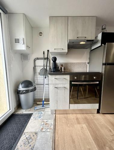 a kitchen with white cabinets and a sink at Studio le moutik Room du bord de mer avec SPA et sauna parking gratuit in Lampaul-Plouarzel