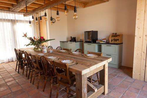 una gran mesa de madera en una habitación con cocina en De Lierhand, en Lier