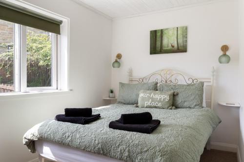 ein Schlafzimmer mit einem Bett mit zwei Kissen darauf in der Unterkunft 'Haworth Haven', Warm Winter Cottage Getaway in Haworth