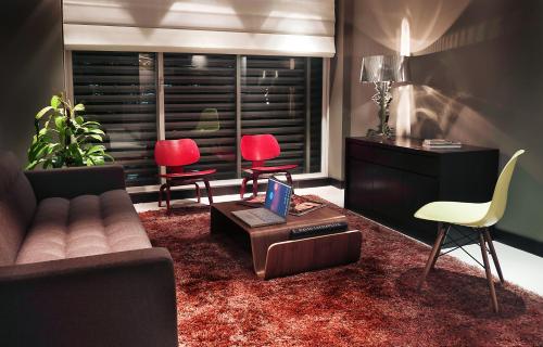 a living room with a couch and two red chairs at Hotel 286 in Ciudad Guayana