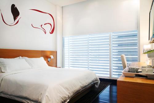 a bedroom with a bed and a large window at Hotel 286 in Ciudad Guayana