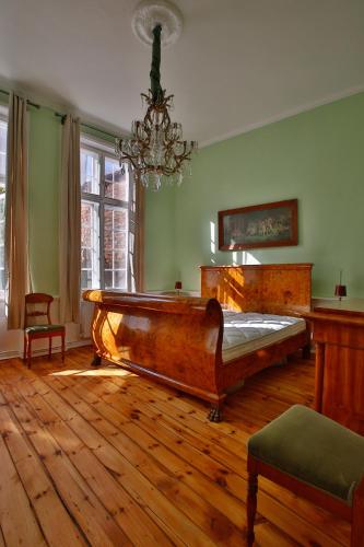 a bedroom with a wooden bed and a chandelier at Ferienwohnung Coco in Lübeck