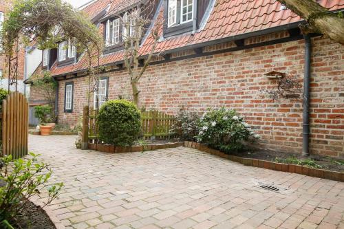 a brick house with a brick courtyard in front of it at Ferienwohnung Coco in Lübeck