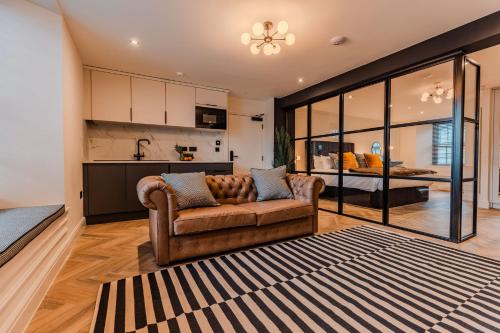 a living room with a couch and a kitchen at Luxury Georgian Aparthotel by Hauss Ayr - 5mins to Beach, Town Centre! in Ayr