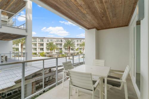 balcón con mesa y sillas y vistas a un edificio en The Pointe Unit 122 by 30A Escapes, en Rosemary Beach