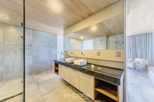 a bathroom with two sinks and a large mirror at NWTs - Estúdios em Prédio com Vista Mar in Maceió