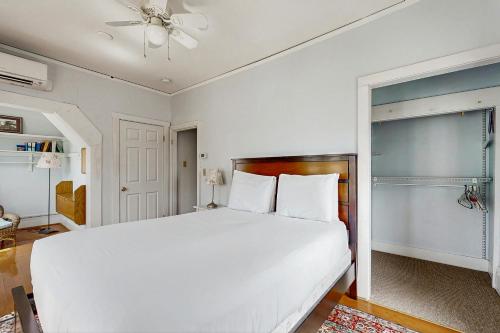 a bedroom with a white bed and a ceiling fan at Windows on the Sea in Rockland