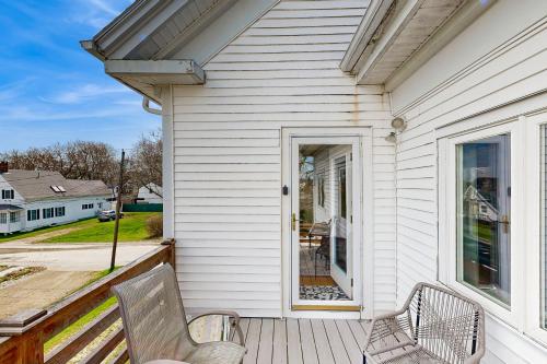 a white house with two chairs on a porch at Windows on the Sea in Rockland