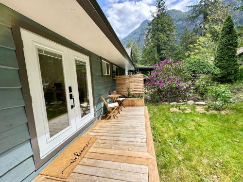 a porch of a house with a table and chairs at Posada Nordica - a chic, tranquil mountainview suite in Hope