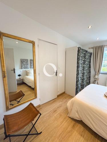 a bedroom with a mirror and a bed and a chair at COC - La Palme in Wissant