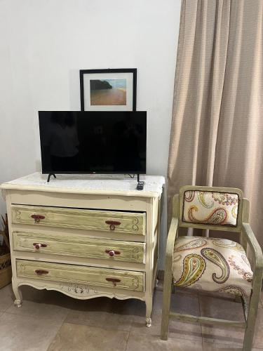 a dresser with a tv and a chair in a room at La Casona de Emilia in Corrientes