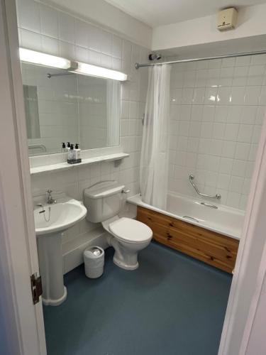 a bathroom with a toilet and a tub and a sink at Harbour Mill Apartment in Westport