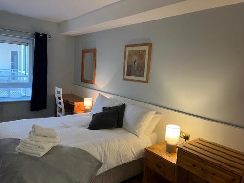 a bedroom with a bed with two lamps and a window at Harbour Mill Apartment in Westport