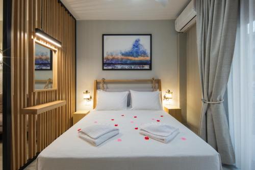 a bedroom with a bed with towels on it at GAIA Suites in Fanárion