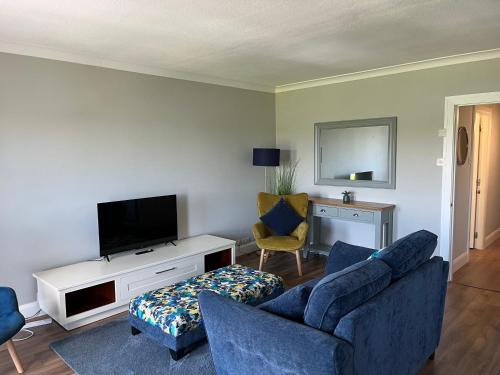 a living room with a couch and a tv at Harbour Mill Apartment in Westport