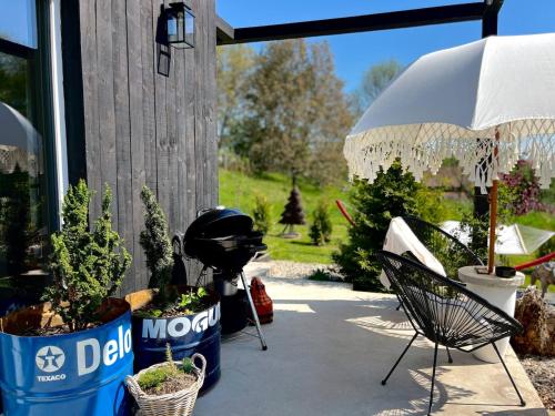 a patio with a chair and some plants and an umbrella at Garden Residence - The Nest in Drahobudice