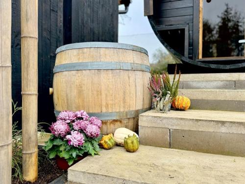 a wooden barrel with flowers and pumpkins on the steps at Garden Residence - The Nest in Drahobudice