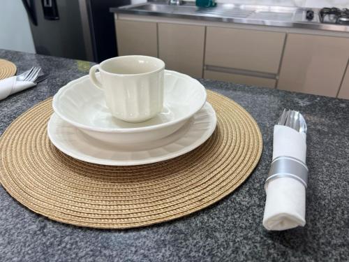 a white coffee cup and a plate on a table at CENTRO historico y CC FUNDADORES in Manizales