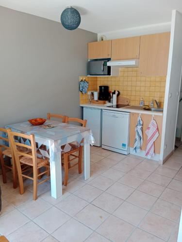 une cuisine avec une table et des chaises dans une pièce dans l'établissement Le petit logis de Lascaux, à Montignac