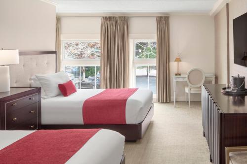 a hotel room with two beds and a desk at Portland Regency Hotel & Spa in Portland