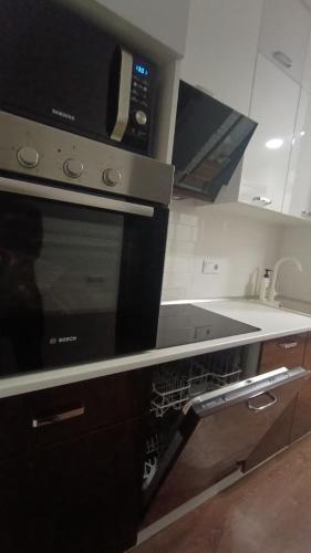 a kitchen with a stove and a microwave at VIP Apartments 9 in Odesa