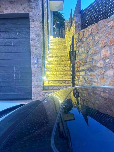 a car parked in front of a yellow stairs at Villa Nova Bar in Zaljevo