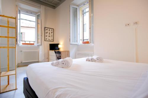 a bedroom with a large white bed with towels on it at Elegantis Trastevere Modern Apartment - Comfort in Rome Most Charming District in Rome