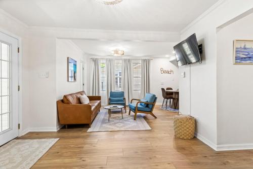 a living room with a couch and chairs and a tv at NO WORRIES! Beachy cottage 5 Minute walk to beach in Gulfport