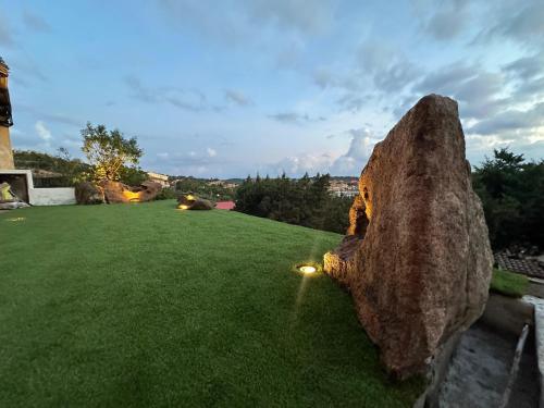 a large rock sitting on top of a grass field at Casa Alessandra, Apartment in Porto Cervo in Porto Cervo