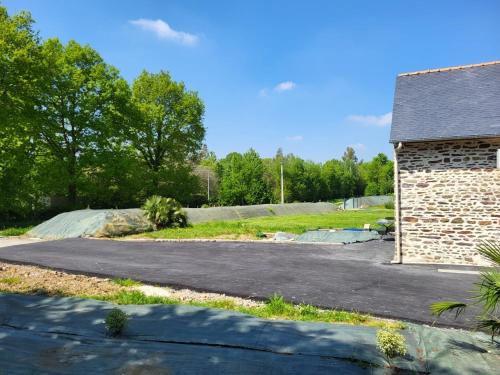 an empty driveway next to a brick building at Un Bibou de Campagne 1 in Le Theil-de-Bretagne