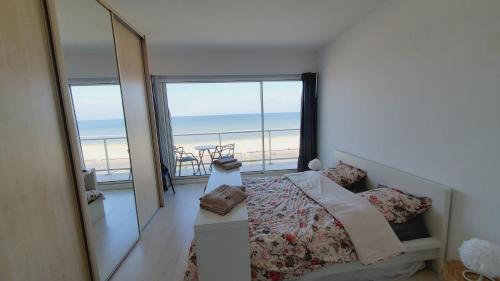 une chambre avec un lit et une vue sur la plage dans l'établissement LTPP T2 face mer, à Le Touquet-Paris-Plage
