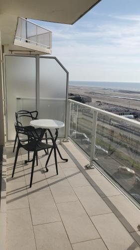 une table et une chaise sur le balcon d'un bâtiment dans l'établissement LTPP T2 face mer, à Le Touquet-Paris-Plage