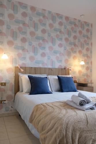 a bedroom with a large bed with blue pillows at Adria Art Apartments 3 in Adria