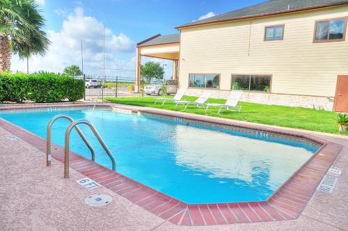 a swimming pool in the yard of a house at Lone Star Inn and Suites Victoria in Victoria
