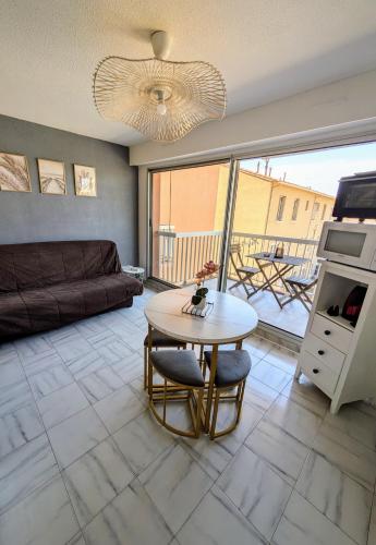 un salon avec une table et un canapé dans l'établissement Appartement Valras - Bord de mer, à Valras-Plage