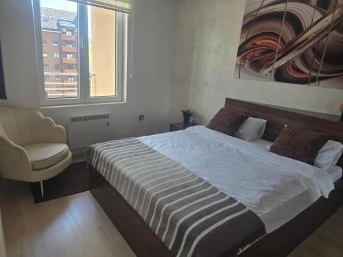 a bedroom with a bed and a chair and a window at Sunny view in Zlatibor