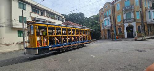 a trolley filled with people riding down a street at Luxo na Gloria in Rio de Janeiro