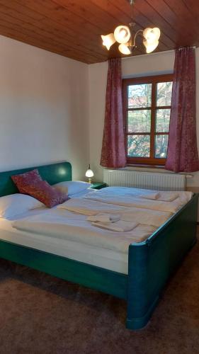 a large bed in a bedroom with a window at Penzion Ztracený mlýn in Slapy