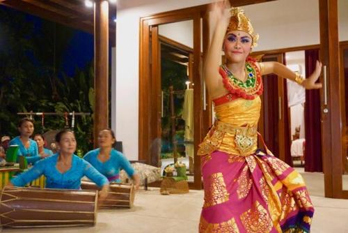 a woman is dancing in a room with other people at Wake up to the Sea of Bali Beachfront luxury plus in Singaraja