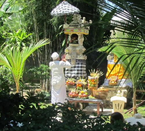 a woman standing in front of a fruit stand at Wake up to the Sea of Bali Beachfront luxury plus in Singaraja