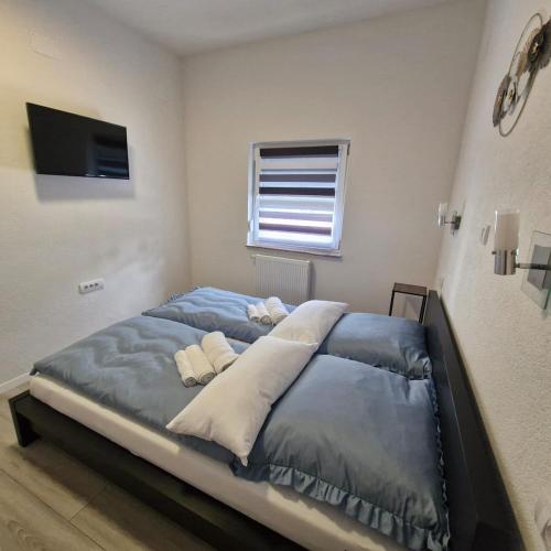 a bedroom with a large bed with blue sheets at Vila Natasa Apartment 5 near Plitvice in Vrhovine