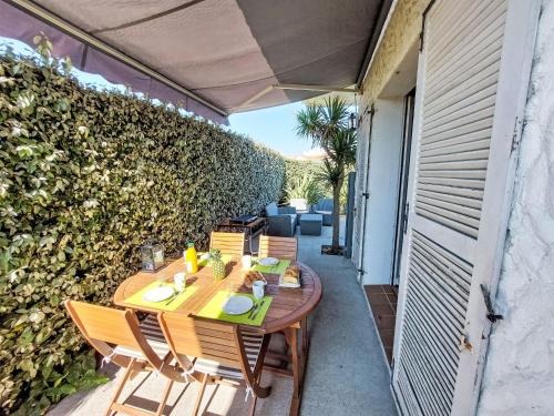 a wooden table and chairs on a patio at Holiday Home Proche Océan- forêt et commerces by Interhome in Fromentine
