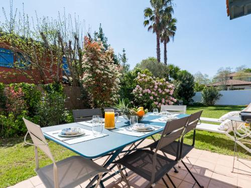 une table bleue avec des chaises dans un jardin dans l'établissement Villa Espérance by Interhome, à Anglet